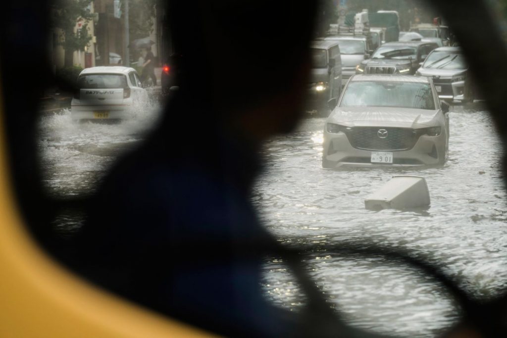 Sudden deluge of rain floods some streets and halts air and rail visitors in Tokyo